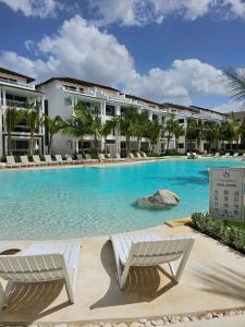 a swimming pool with two chairs in front of a building at Paradise Dream Dominicus in La Laguna