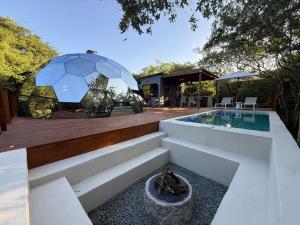 a backyard with a swimming pool and a house at The Dome Luxury Safari Villa in Hluhluwe