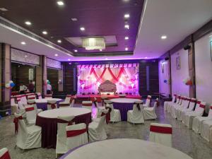 een banketzaal met tafels en stoelen en een podium bij Hotel Brahmani in Jajpur Road +20 foto's