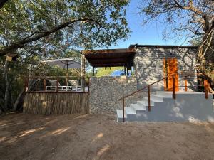 a stone house with a staircase and a patio at The Dome Luxury Safari Villa in Hluhluwe