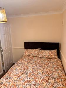 een slaapkamer met een bed met een dekbed bij Cozy Nest in Grays Thurrock