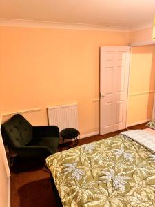 een slaapkamer met een bed en een stoel bij Cozy Nest in Grays Thurrock +1 foto