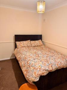 een slaapkamer met een bed met een dekbed erop bij Cozy Nest in Grays Thurrock