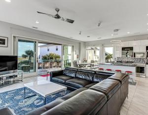 een woonkamer met een leren bank en een tafel bij Ocean View Modern in Tybee Island