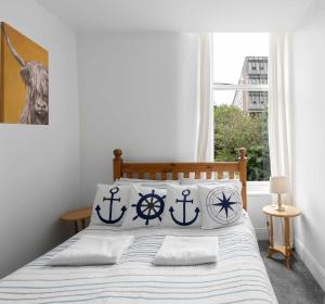 a bedroom with a bed with anchor pillows on it at The Hidden Asset- Rothesay, Isle of Bute in Rothesay
