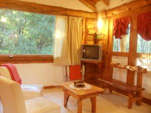 a living room with a table and a tv at Patagonia Playa Cielo in Mar de las Pampas