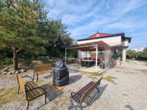 a group of benches in front of a building at 와바다펜션 속초고성 독채펜션12인 삼포해수욕장1분 바베큐불멍 in Goseong