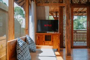 a living room with a tv and a couch at Mandara villas ubud in Tegalalang
