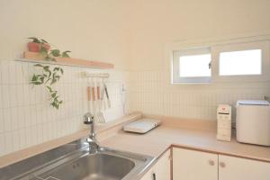 a kitchen with a sink and a microwave at 넓고 편리한 숙소 in Pongsan-dong