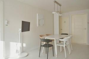 a white dining room with a white table and chairs at 넓고 편리한 숙소 in Pongsan-dong +27 photos