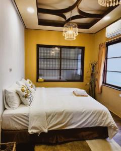 台南市にある包棟-事務所洋樓 The Remote Living-台南獨棟古典洋樓8-10人 停四台車の大きなベッドとシャンデリアのある寝室
