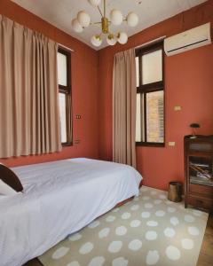 台南市にある包棟-事務所洋樓 The Remote Living-台南獨棟古典洋樓8-10人 停四台車のオレンジ色の壁のベッドルーム1室(白いベッド1台付)