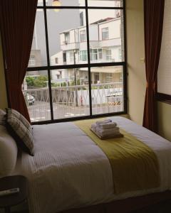 台南市にある包棟-事務所洋樓 The Remote Living-台南獨棟古典洋樓8-10人 停四台車のベッドと大きな窓のある寝室 +37枚の写真