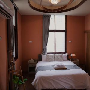 台南市にある包棟-事務所洋樓 The Remote Living-台南獨棟古典洋樓8-10人 停四台車の大きなベッドと大きな窓のある寝室