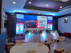 een conferentiezaal met 2 tafels en een groot scherm bij Hotel Brahmani in Jajpur Road