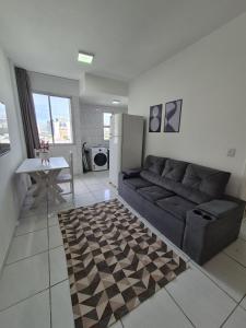 a living room with a couch and a table at Flat quarto e sala completo in Vitória +73 photos