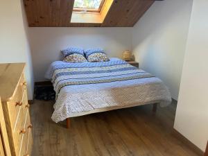 ein Schlafzimmer mit einem Bett mit einer blau-weißen Bettdecke in der Unterkunft La Lézardière - Chalet spacieux près des pistes in La Toussuire
