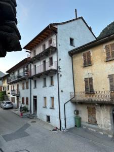 a white building with balconies on the side of it at Historische Unterkunft Casa Tre Valli in Biasca +3 photos