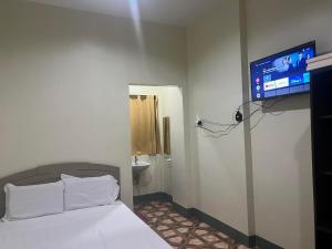 a bedroom with a bed and a tv on the wall at Feel Home Suites in Pagadian