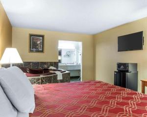 a hotel room with a large bed and a bathroom at Econo Lodge Dalton West in Dalton