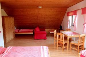 Chata v Beskydech في أوسترافيس: غرفة بسرير وطاولة وكراسي