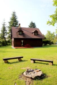 a house with two benches in front of it at Chata v Beskydech in Ostravice