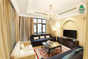 a living room with a couch and a tv at Souk Al Bahar View Burj Khalifa and Fountains Dream View Holiday Homes in Dubai