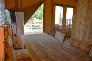 ein Esszimmer mit einem Holztisch und einer Glasschiebetür in der Unterkunft Il Castagno Toscana in Campiglia Marittima