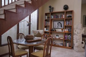 a dining room with a table and chairs and a book shelf at Gilded Palms Villa, Ubud Payangan, Bali in Payangan