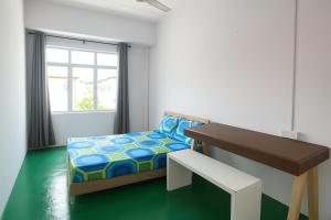 ein Schlafzimmer mit Bett, Schreibtisch und Fenster in der Unterkunft TK Homie in Tanjung Karang