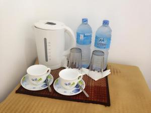 een aanrecht met twee kopjes en twee flessen water bij Riverside Hotel Colombo in Dandugama