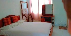 een slaapkamer met een bed, een spiegel en een televisie bij Riverside Hotel Colombo in Dandugama