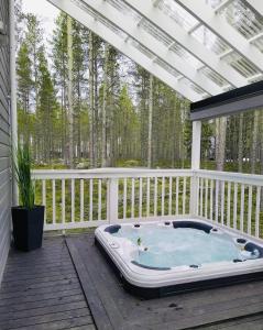 a hot tub on a deck with a pergola at Villa Pinja in Kalajoki