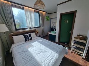 a bedroom with a large bed with a large window at 와바다펜션 속초고성 독채펜션12인 삼포해수욕장1분 바베큐불멍 in Goseong