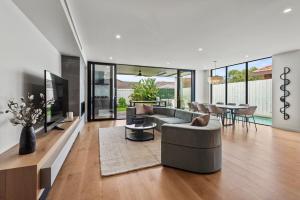a living room with a couch and a table at Bayside Grandeur w Heated Pool,Spa,Sauna,5 Ensuites in Melbourne