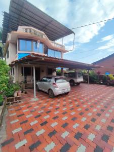 a house with two cars parked in a parking lot at Shri Samarth Homestay in Diveagar