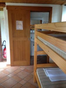 Zimmer mit Etagenbett und Tür in der Unterkunft Ostello Orgnana in Magadino
