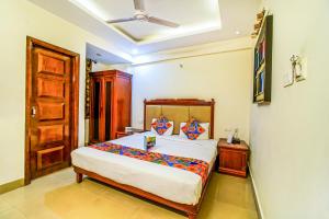 a bedroom with a large bed and a wooden door at Hotel Kenil Star in Dehradun +12 photos