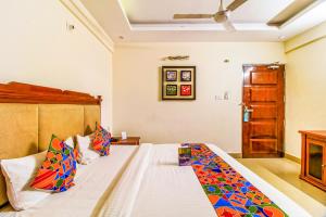 a bedroom with a large bed with colorful pillows at Hotel Kenil Star in Dehradun