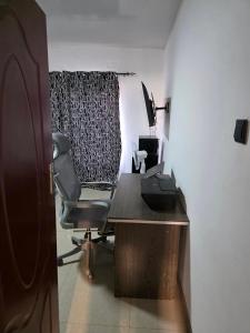 an office with a desk with a chair and a computer at sarahs apartments solwezi in Mpemba