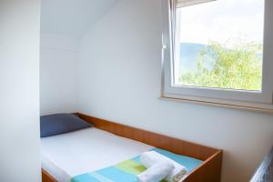 Una cama pequeña en una habitación con ventana. en Holiday Home Vemini, en Mostar 40 fotos más