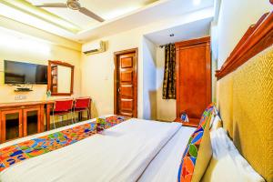 a bedroom with a bed and a table with chairs at Hotel Kenil Star in Dehradun