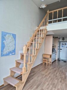 a wooden staircase in a room with a kitchen at Hongdae Residence-5 1min from Hongik Uni station Exit #1 in Seoul
