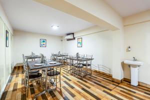 a room with tables and chairs and a sink at Treebo Marina Grand, Railway station in Visakhapatnam
