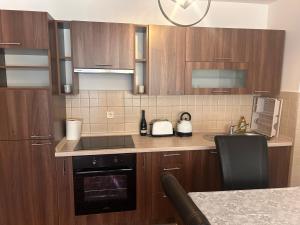 a kitchen with wooden cabinets and a counter top at Atila Nature Home in Bjelašnica