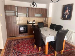 a kitchen with a dining room table with black chairs at Atila Nature Home in Bjelašnica +9 photos