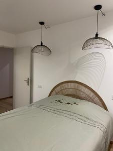 ビアリッツにあるLa Miladyのベッドの上に3つの照明が掛かるベッドルーム