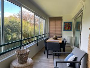 a balcony with a table and chairs and windows at La Milady in Biarritz