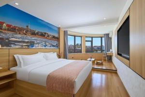 a hotel room with a large bed and a television at Floral Hotel Beidaihe Migao Intelligent Hotel in Qinhuangdao