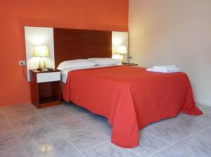 a bedroom with a large bed with a red blanket at Golden Hotel in Quevedo